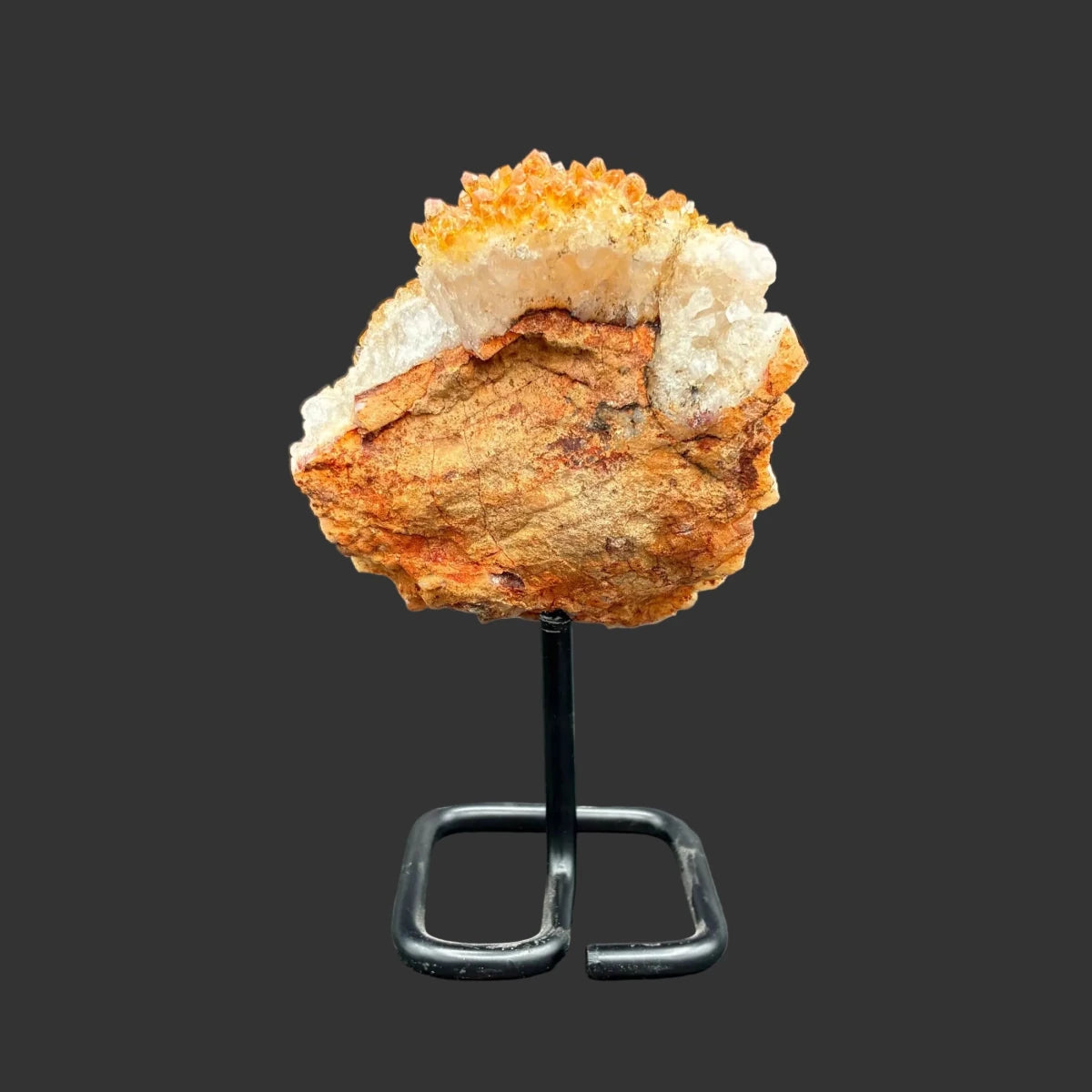 Back side of this citrine on stand, in front of a black background.