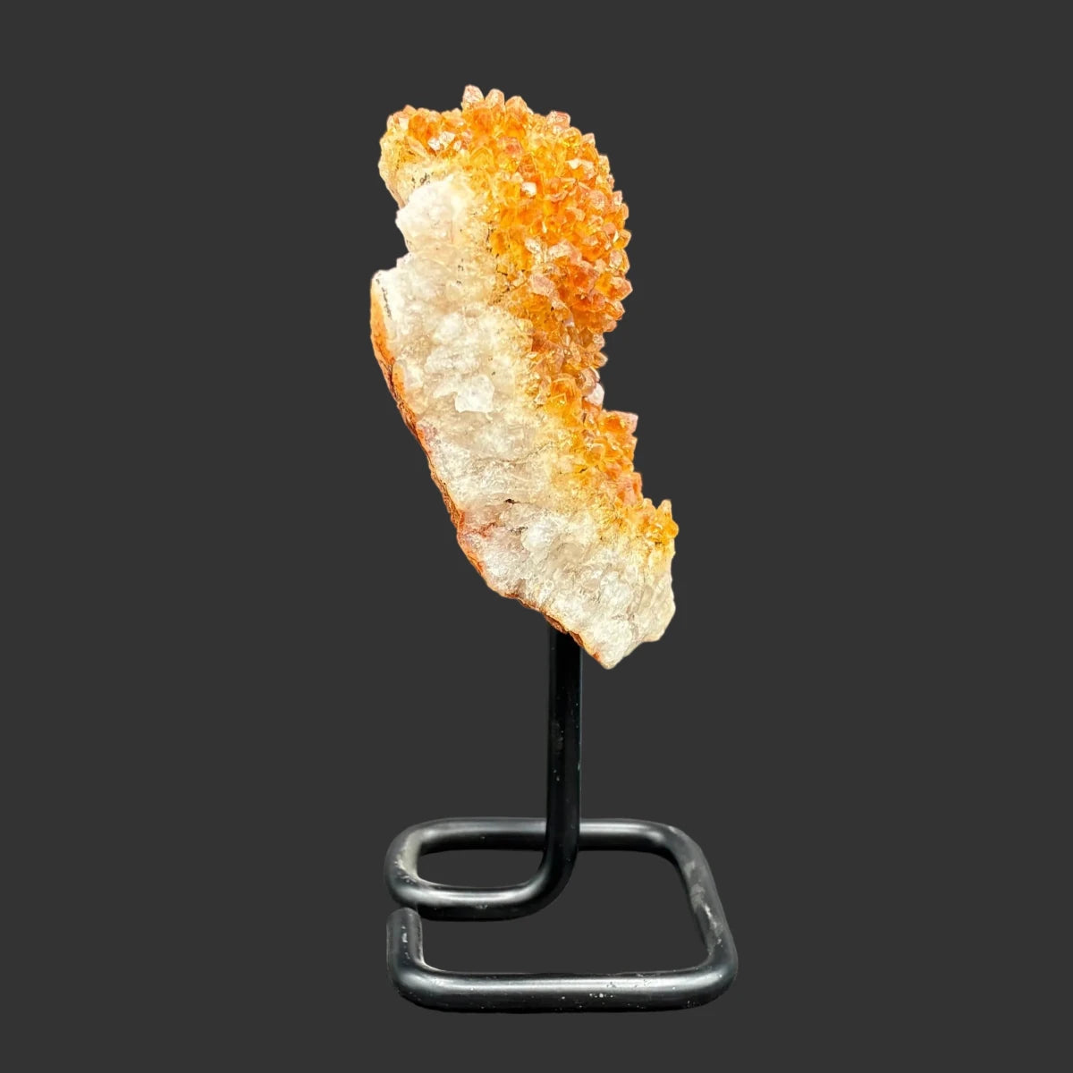 Right side of this citrine on stand, in front of a black background.