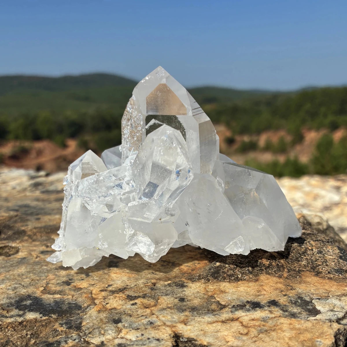 Front side of this quartz crystal cluster, on a rock outdoors.