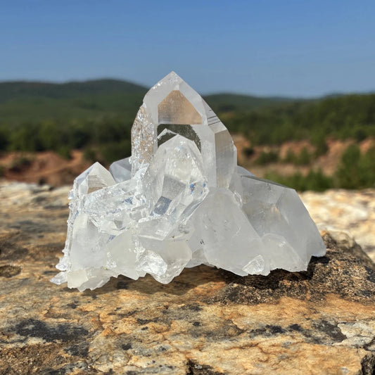 Front side of this quartz crystal cluster, on a rock outdoors.