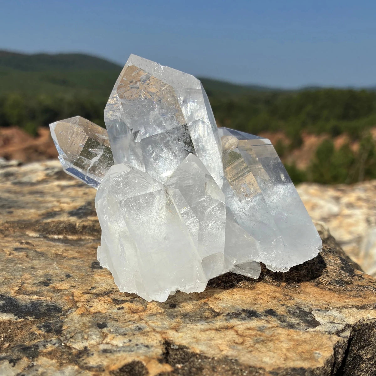 This is the left side of this quartz crystal cluster, on a rock outdoors.