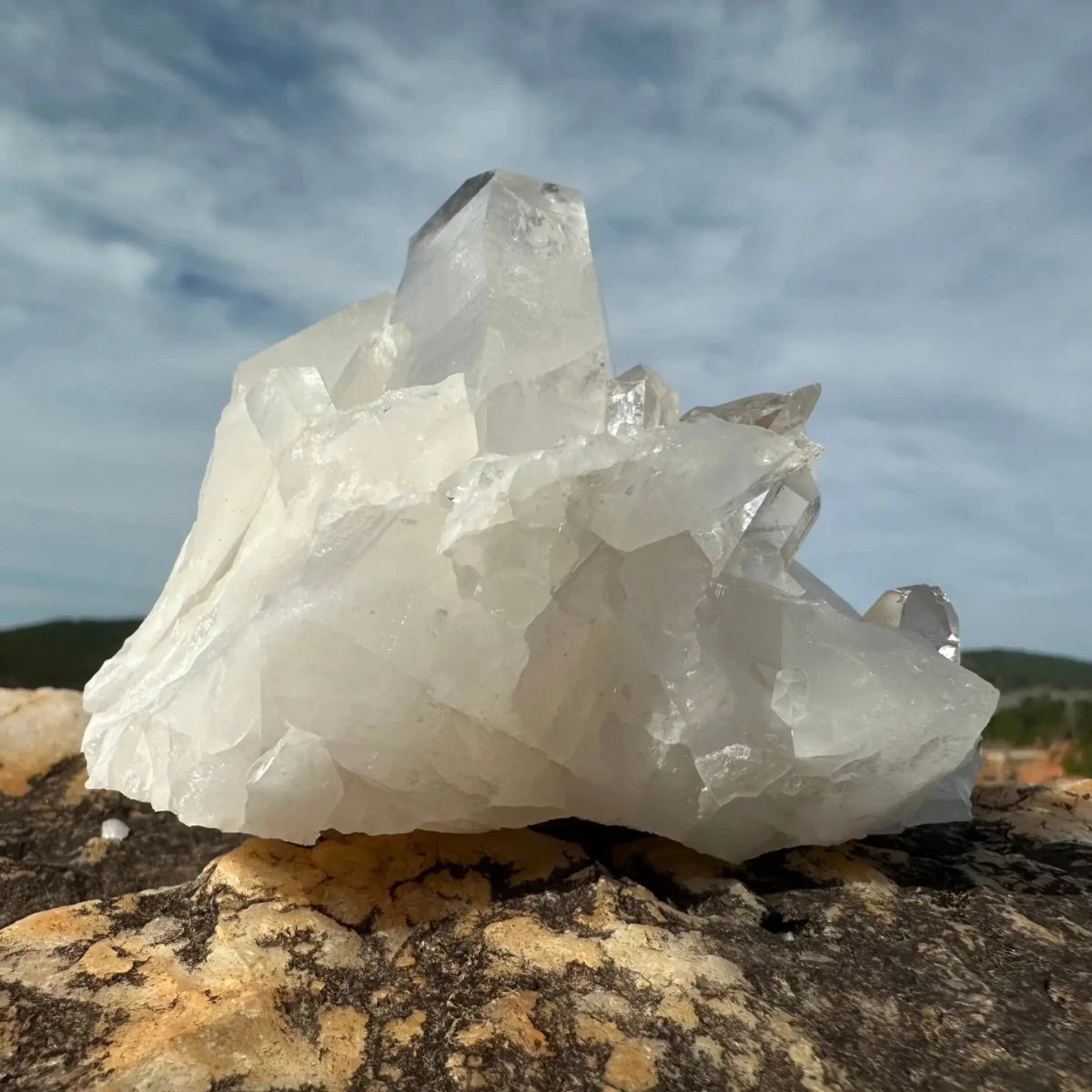 Clear to opaque quartz crystal cluster on a boulder