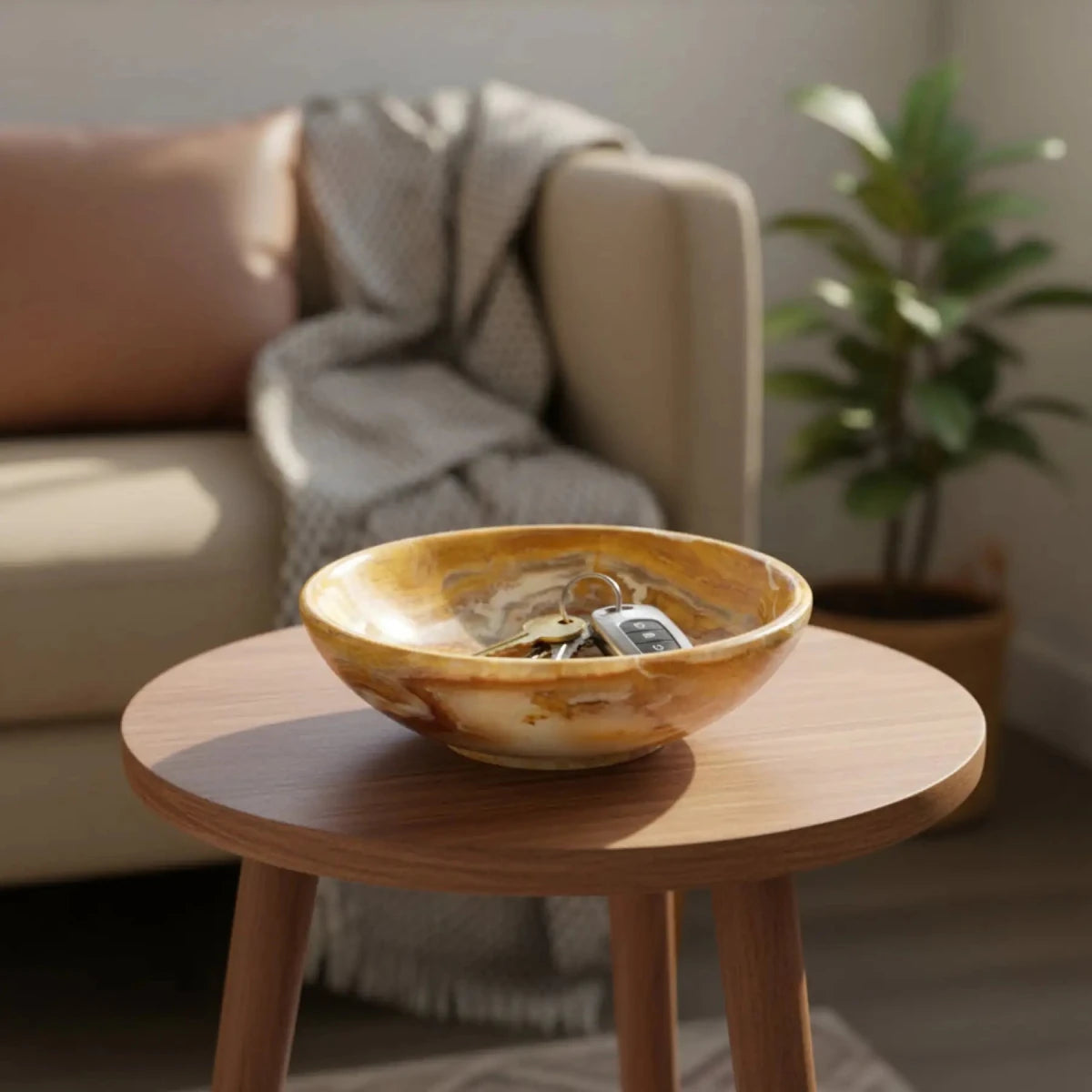 This is the front side of this small, banded onyx bowl on a small table, with keys in it.