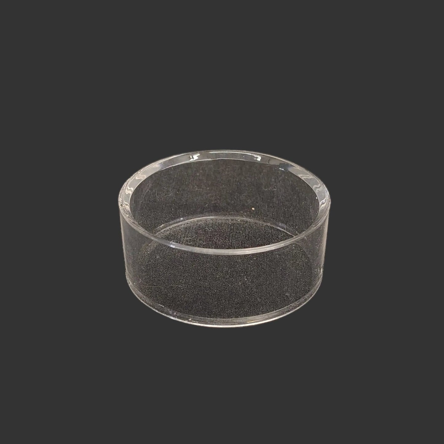 This acrylic riser display stand is clear, glossy, and round in shape.