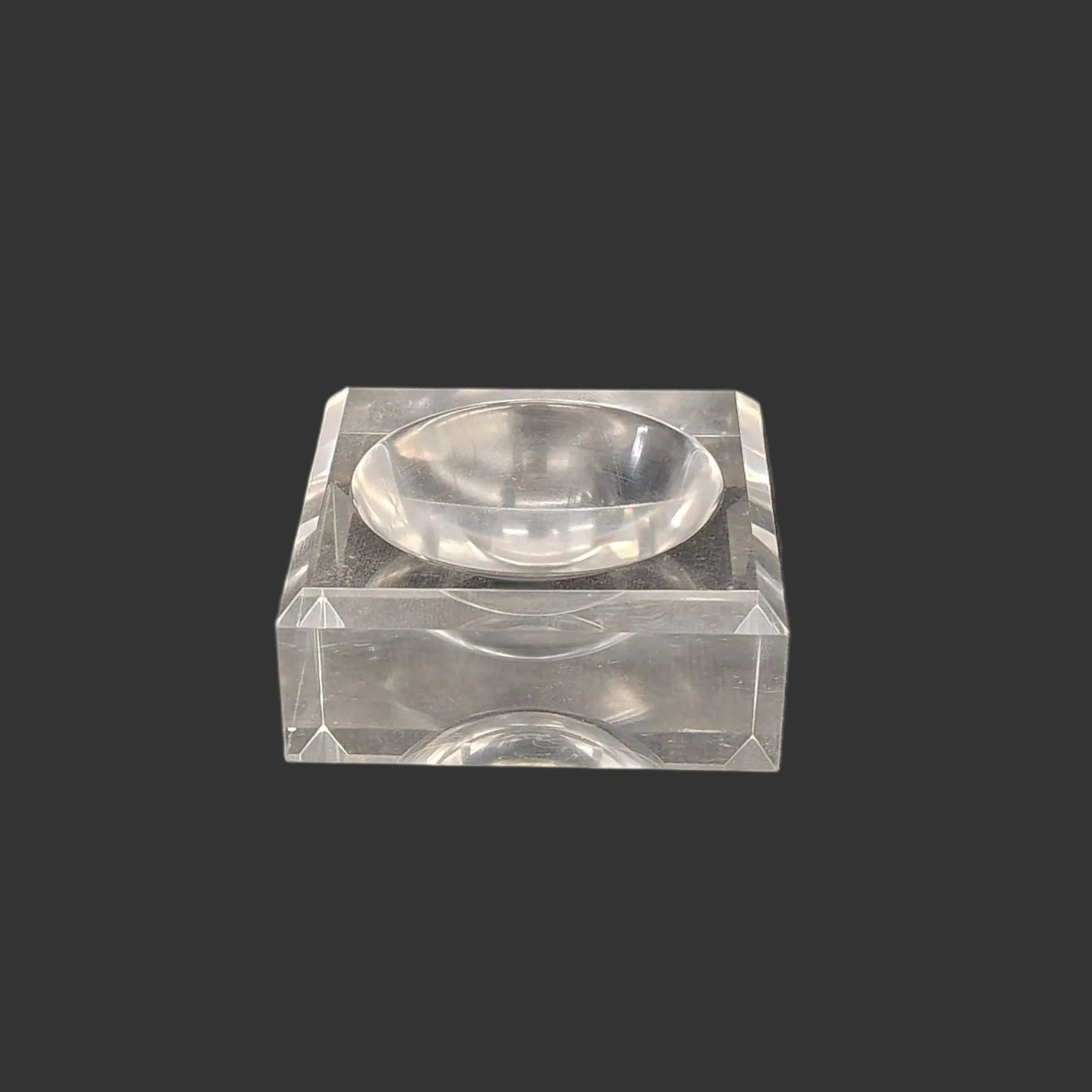 This acrylic stand is clear, glossy, and square in shape.