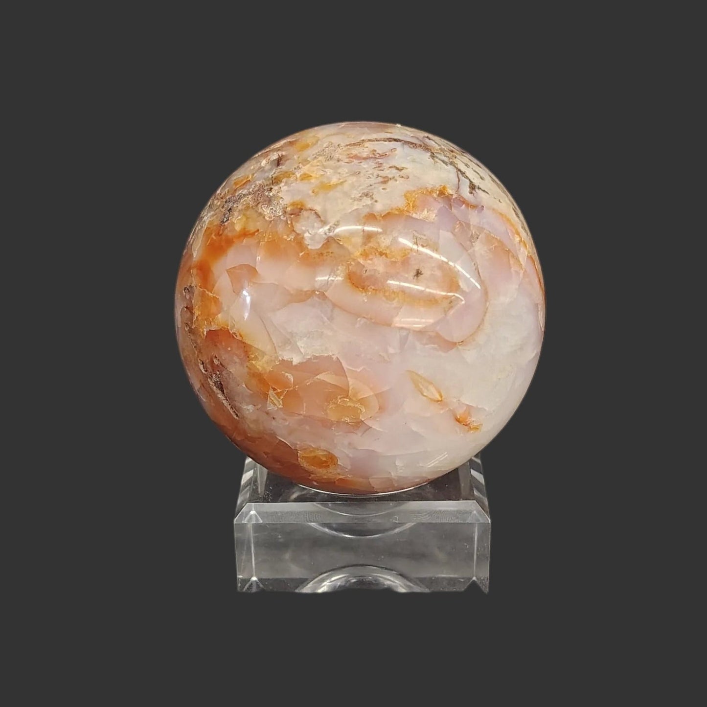 This carnelian sphere is displayed beautifully on this square acrylic display stand.