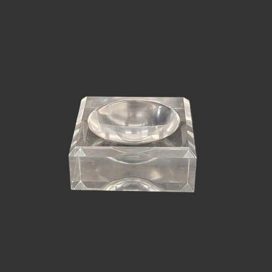 This acrylic stand is clear, glossy, and square in shape.