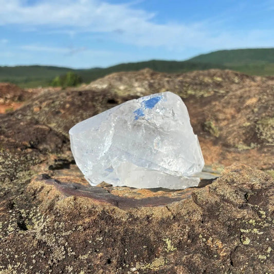 Front view of this double terminated quartz crystal, on a rock and outdoors.