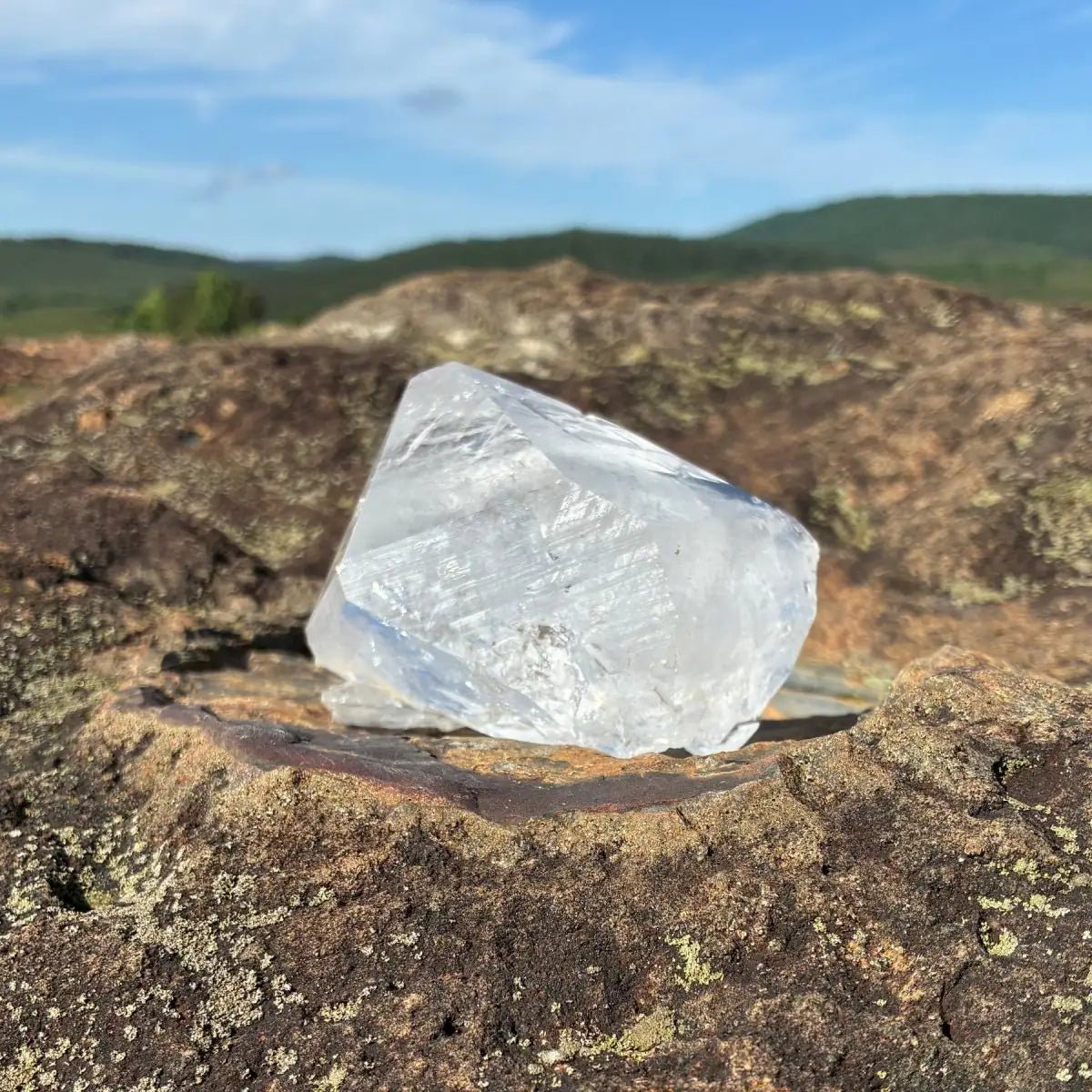 Back side of this double terminated quartz crystal point, on a rock outdoors.