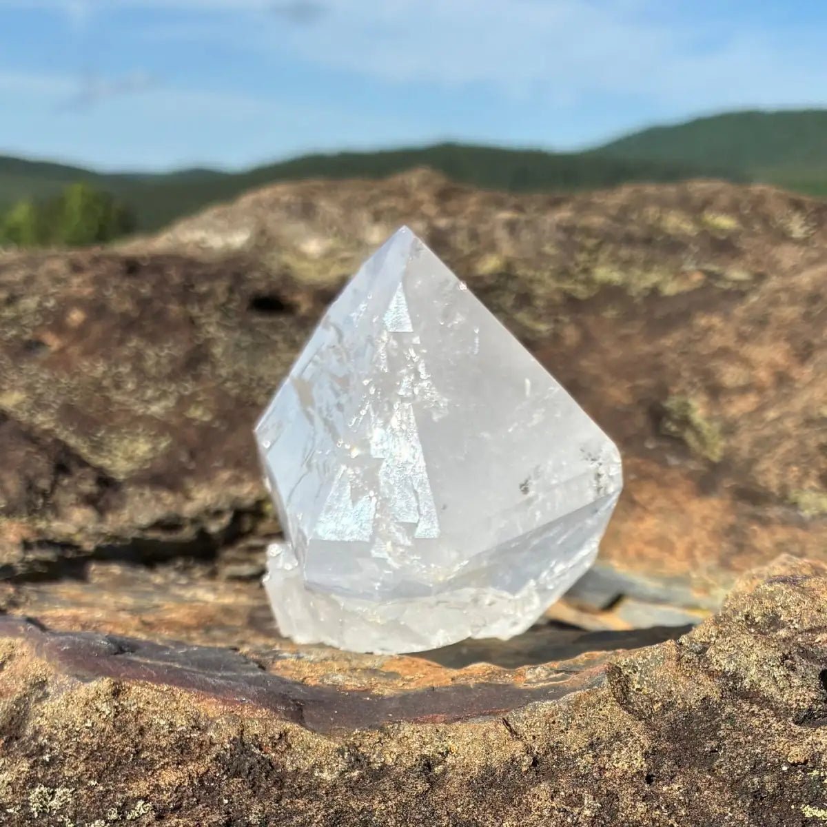 Right side of this double terminated quartz crystal, on a rock outdoors.
