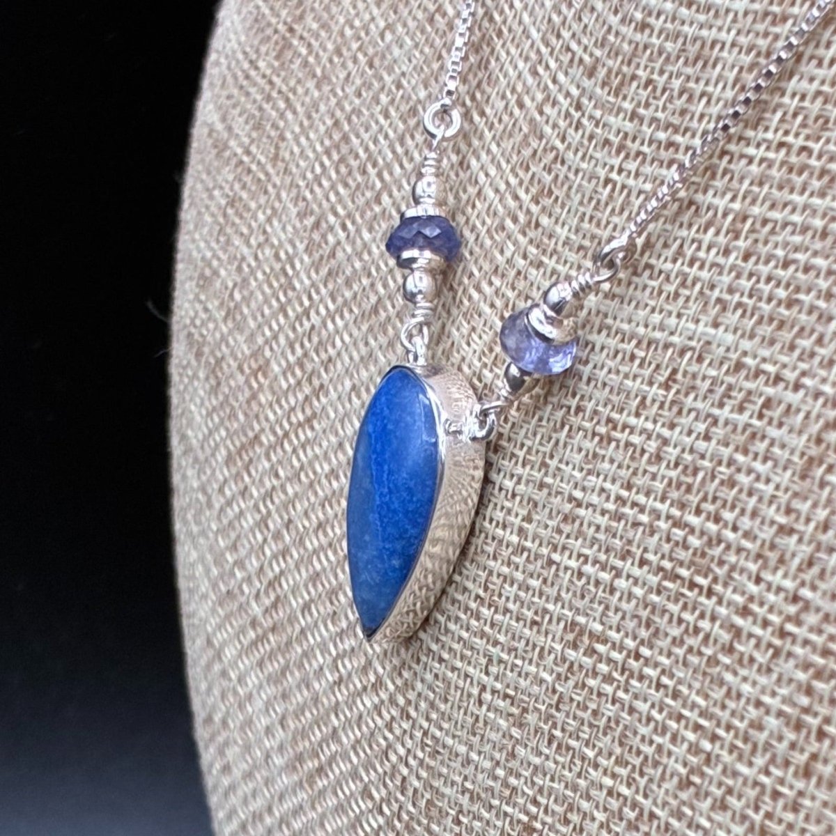Side view of the pendant and iolite beads on this sterling silver necklace.