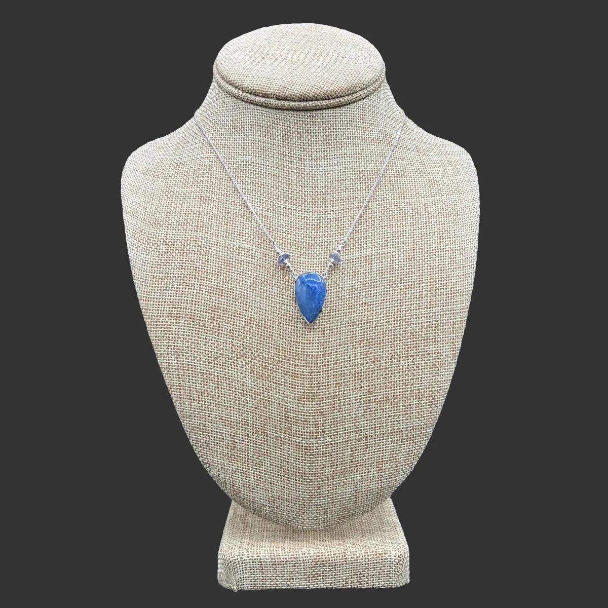 Front view of this sterling silver blue dumortierite and iolite necklace, in front of a black background.