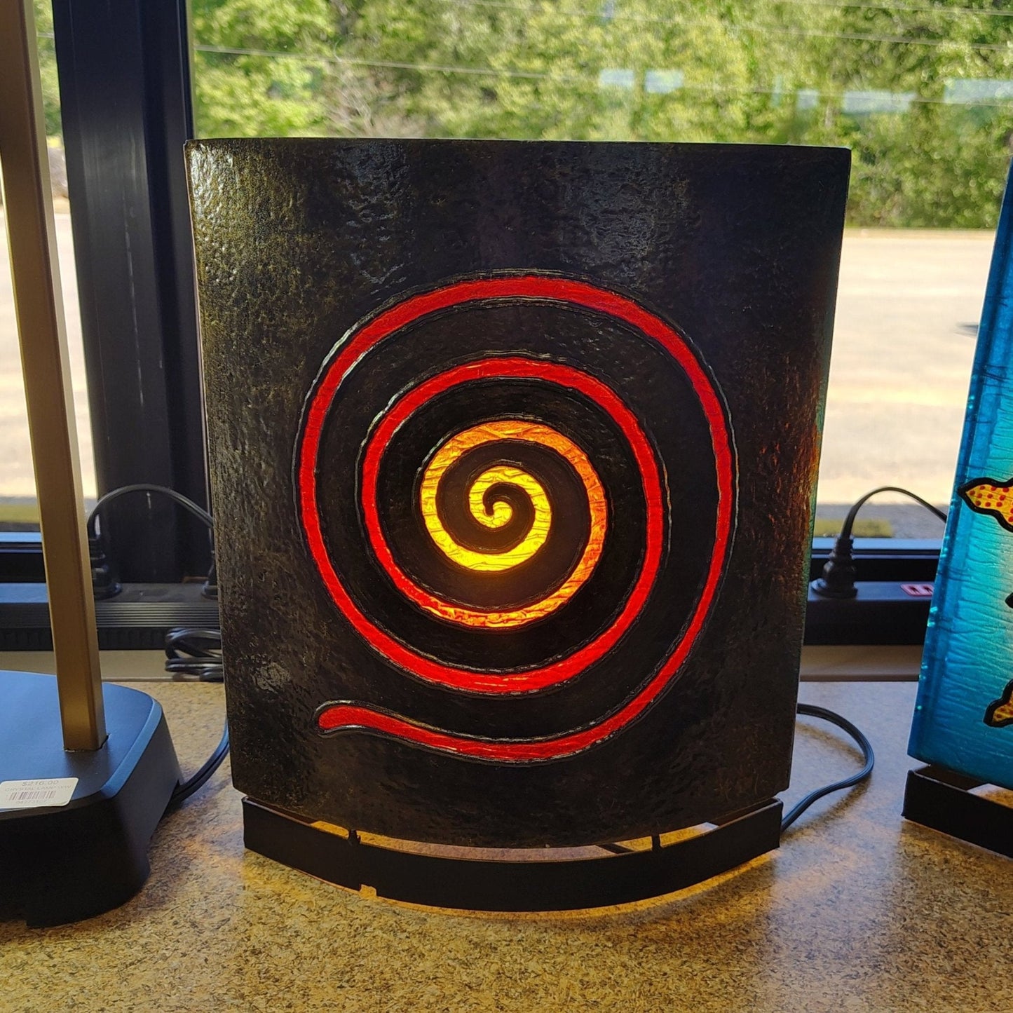 Back side of the flower of life resin lamp. This side has a spiral motif made out of red acrylic.