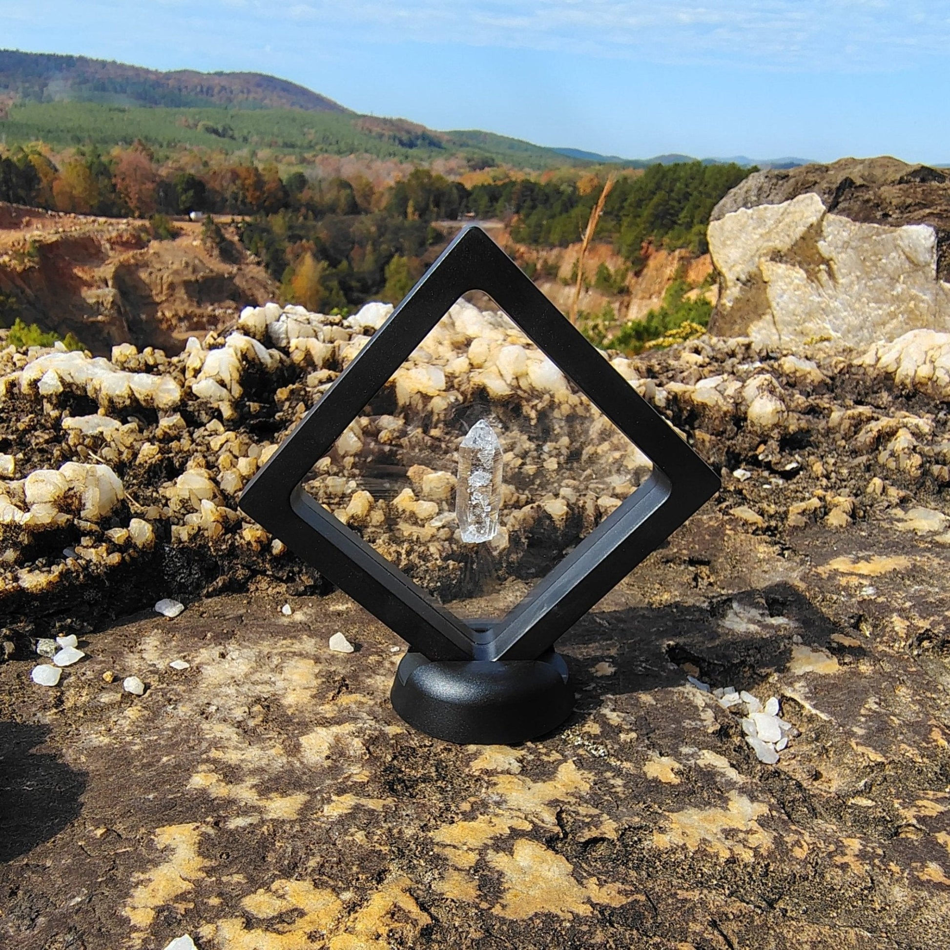 This is a water clear Quartz crystal point in a black frame. Base is removeable