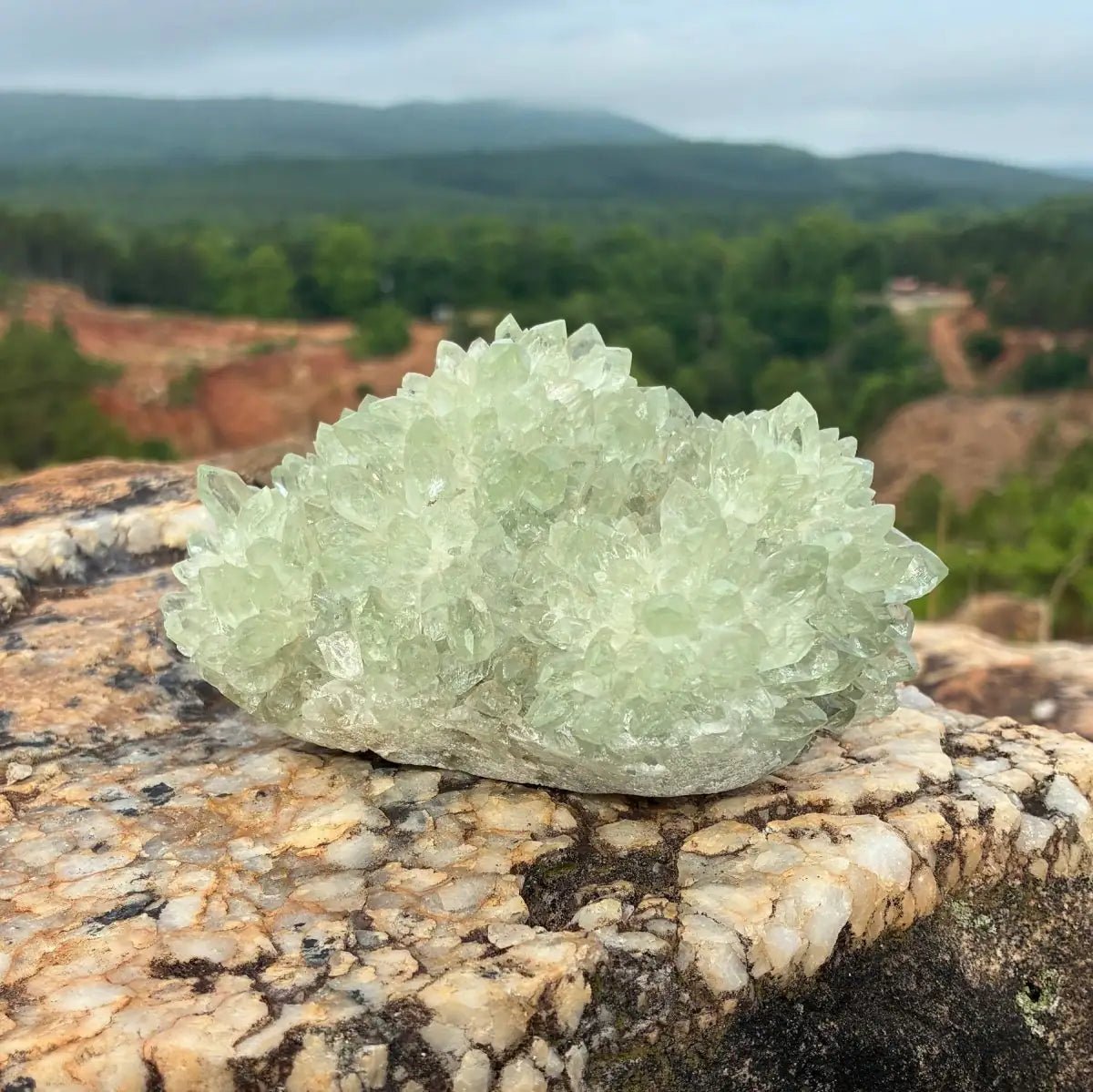 Front side of this green quartz stalagmite cluster, on a boulder outdoors.