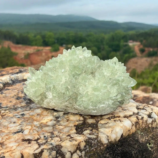 Front side of this green quartz stalagmite cluster, on a boulder outdoors.