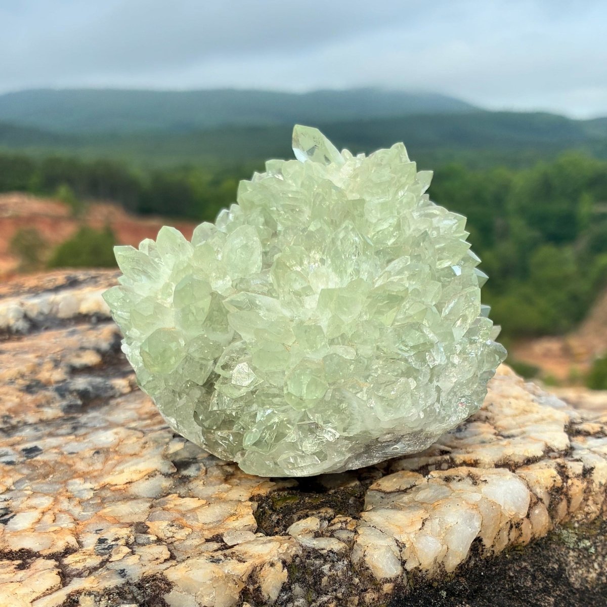 Left side of this green quartz stalagmite cluster, on a boulder outdoors.