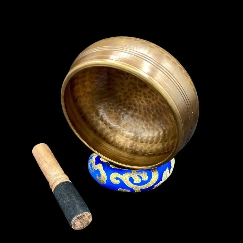 Hammered Copper Singing Bowl On side showing design with cushion and mallet