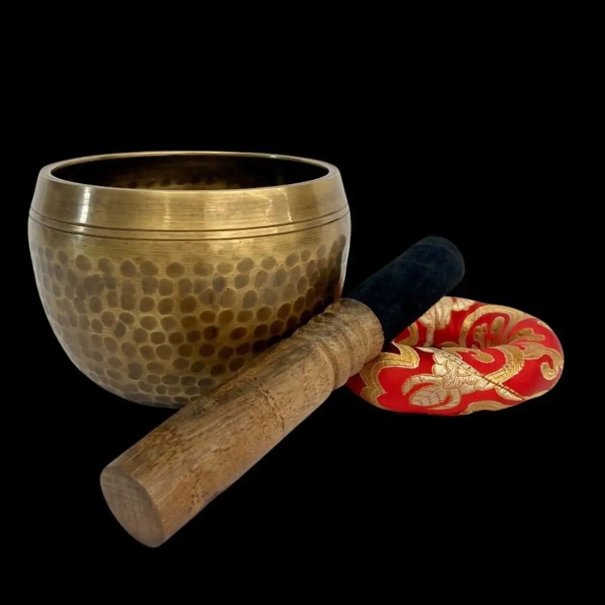 side view of Hammer Singing Bowl with mallet and donut cushion beside it