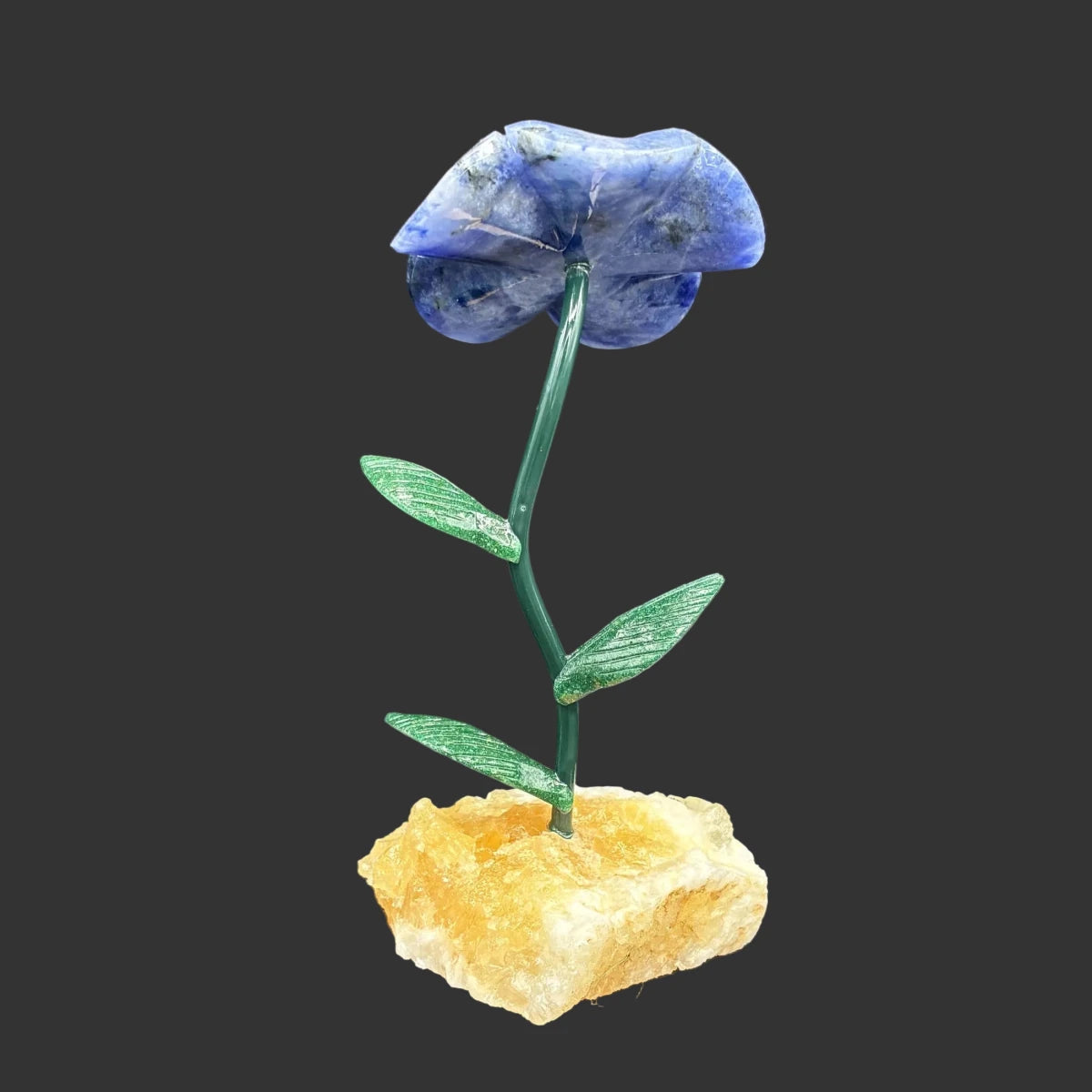 Back side of this blue sodalite flower, in front of a black background.