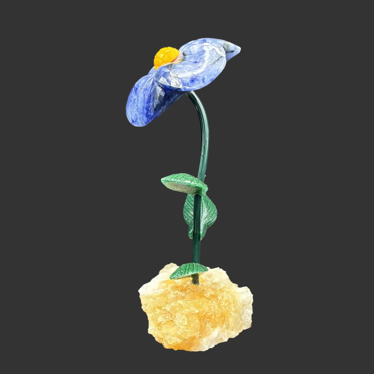 Side view of this blue sodalite flower, in front of a black background.