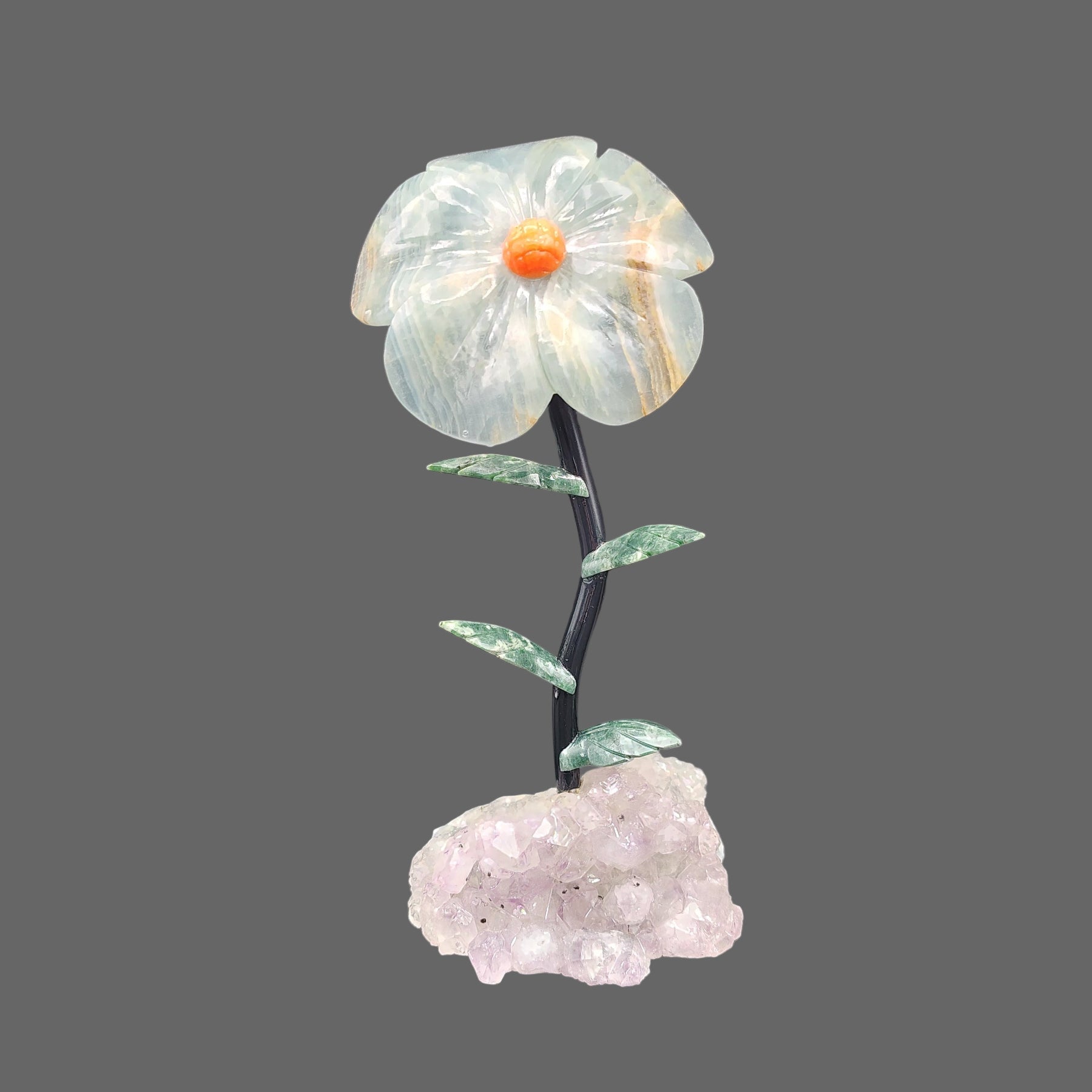 This lovely piece of home decor is a flower made from blue onyx, and on a purple amethyst crystal base.