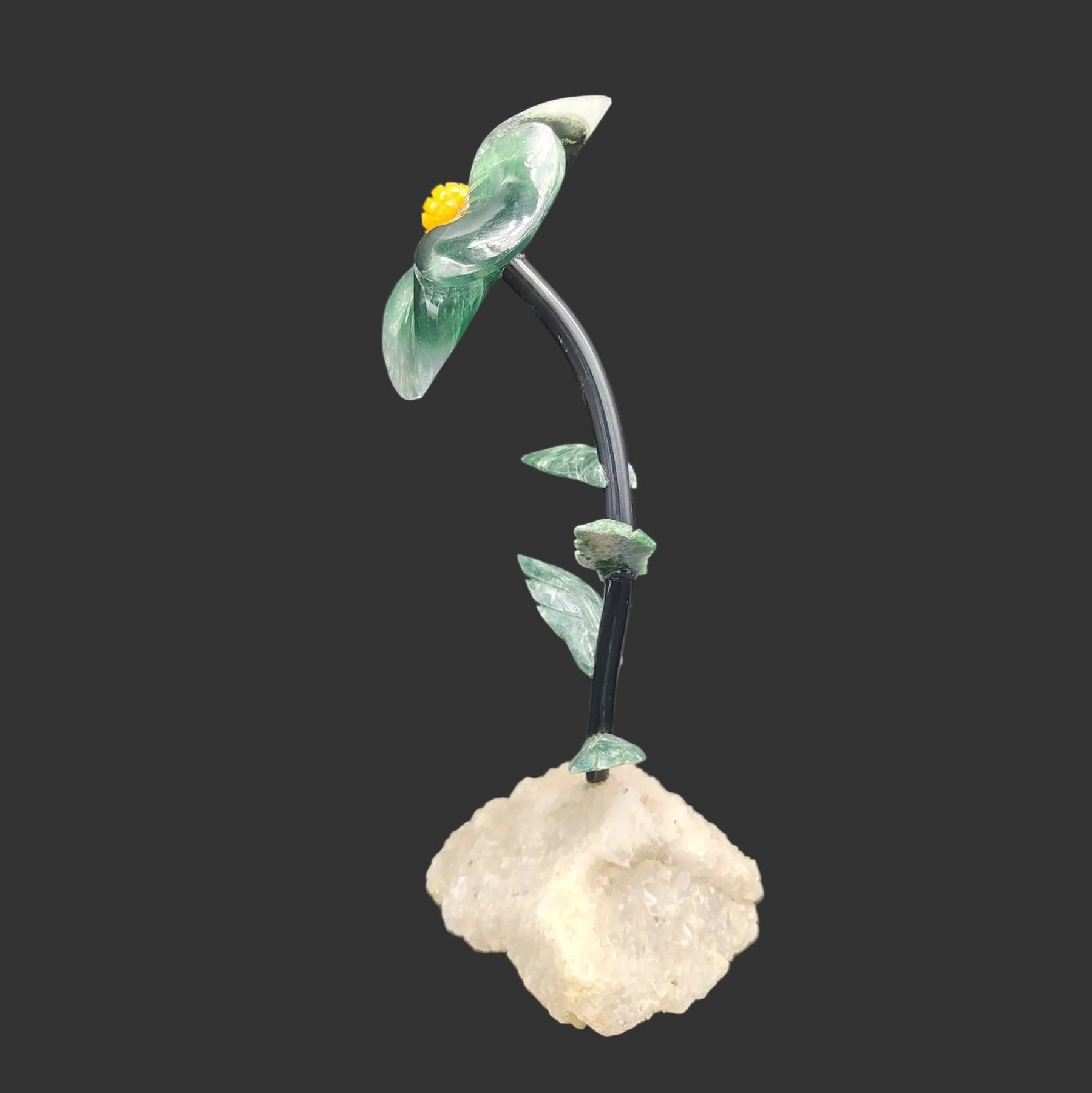 This is the side view of this polished hand carved green Fluorite daisy on a white quartz base.