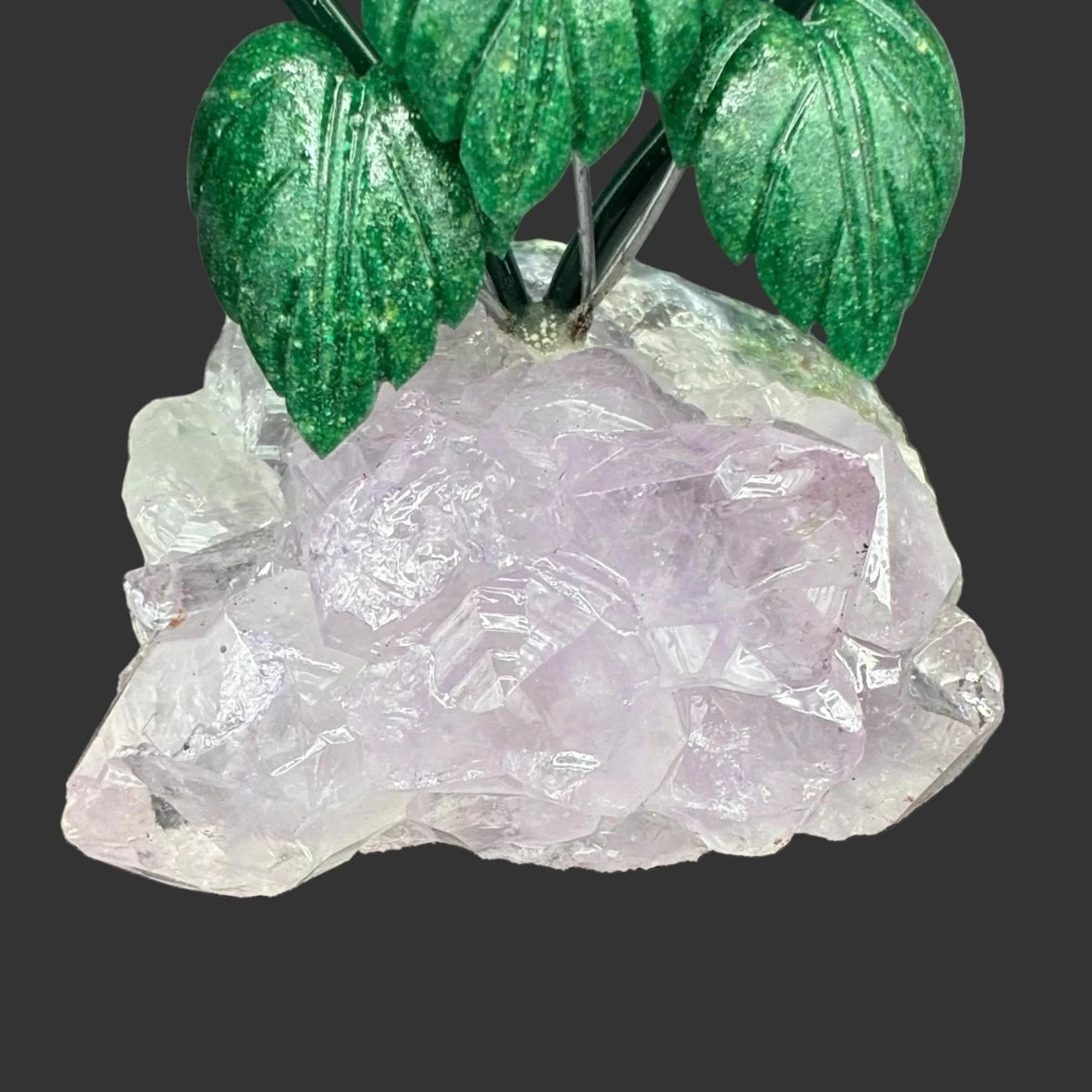 Close up of the Amethyst crystal base, in front of a black background.