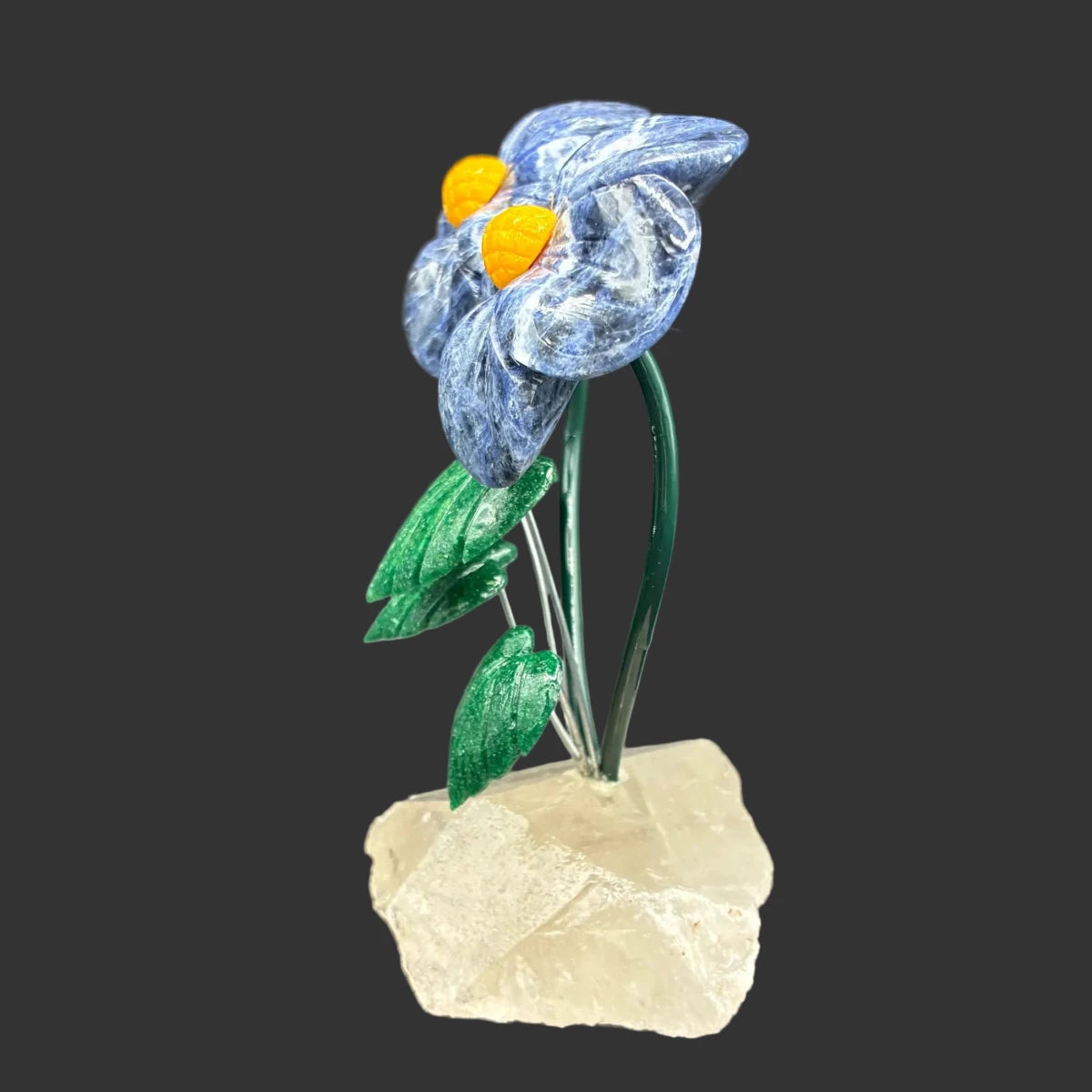 Side view of this double sodalite daisy flower, in front of a black background.