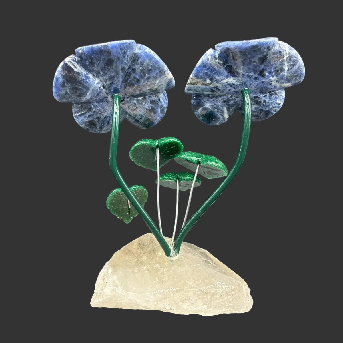 Back side of this sodalite double daisy flower, in front of a black background.