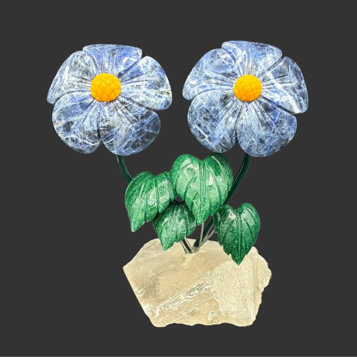 Front side of this sodalite double daisy flower on a quartz crystal base, in front of a black background.