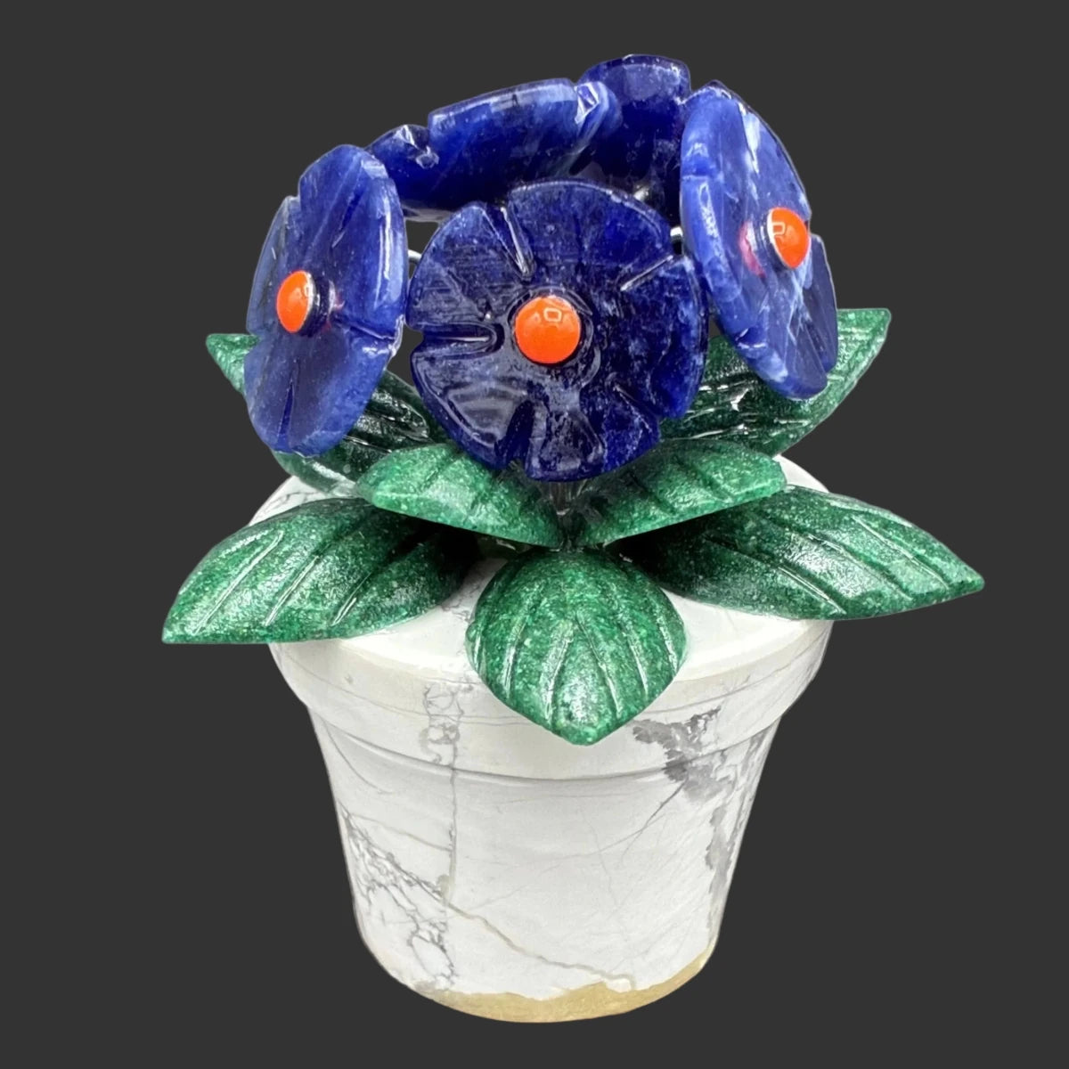 Close up of this mini sodalite gemstone flowerpot, in front of a black background.