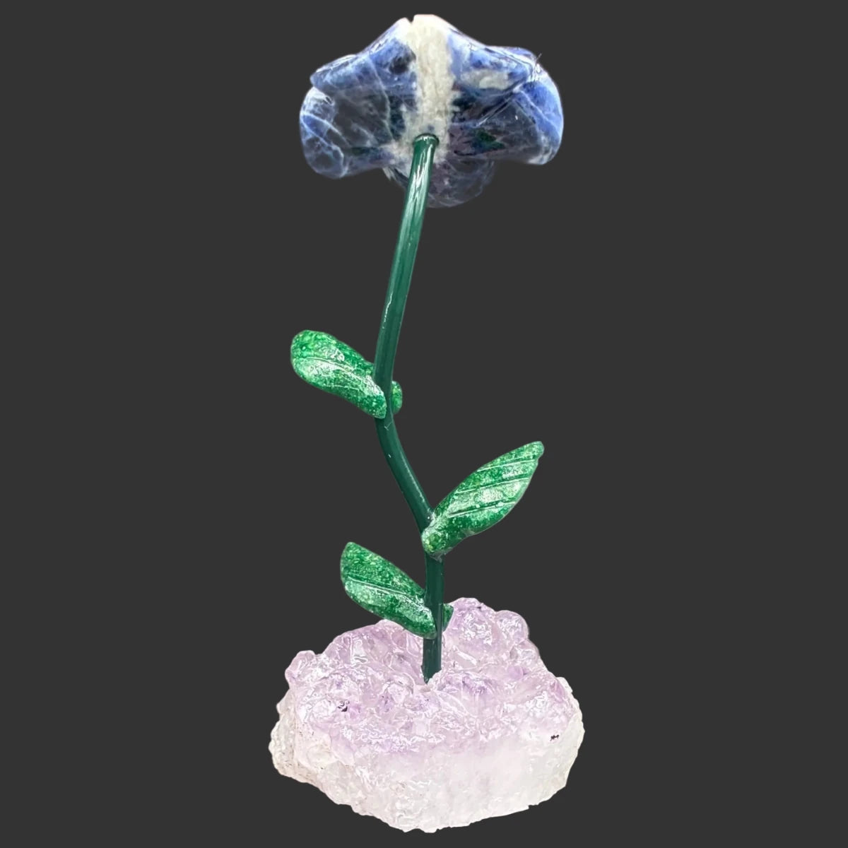 Back side of this sodalite daisy with a amethyst base, in front of a black background.
