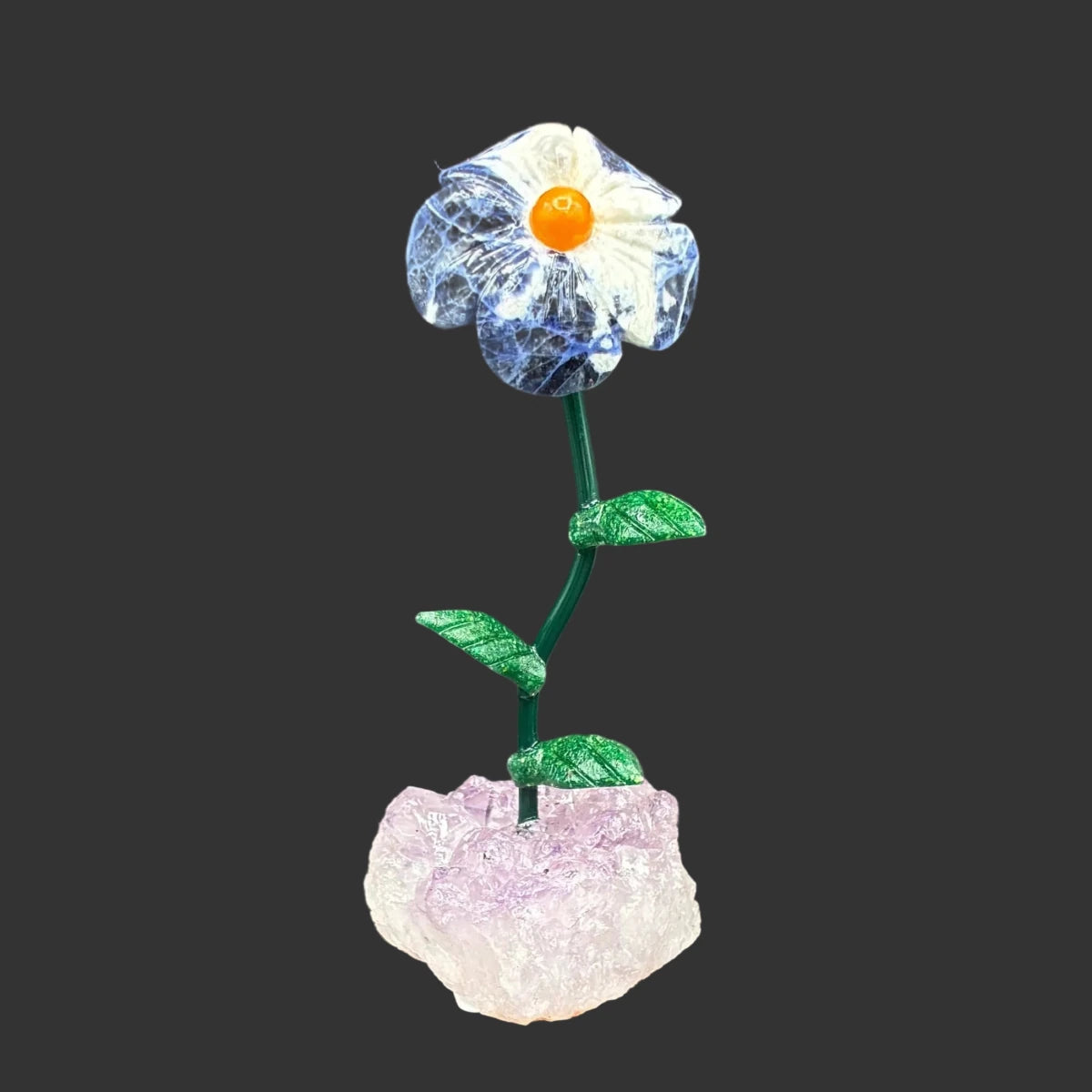 Front side of this sodalite daisy on a amethyst crystal base, in front of a black background.