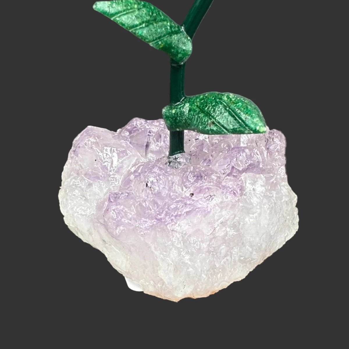 Close up of the amethyst crystal base, in front of a black background.