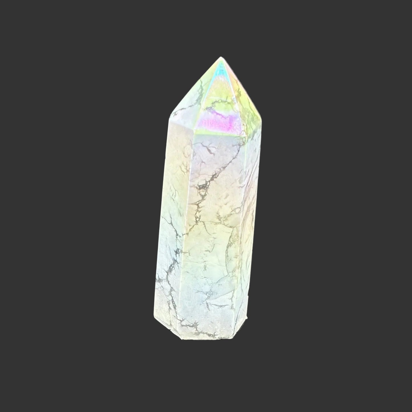 This is the back side of this polished Howlite aura point. It is white with a overtone of blue, yellow, and pink.