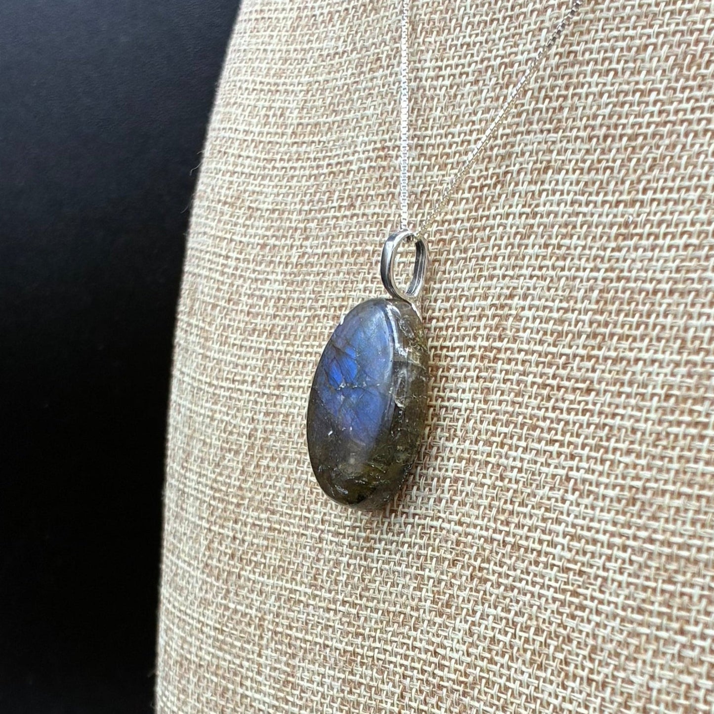 Side view of a polished Labradorite pendant.