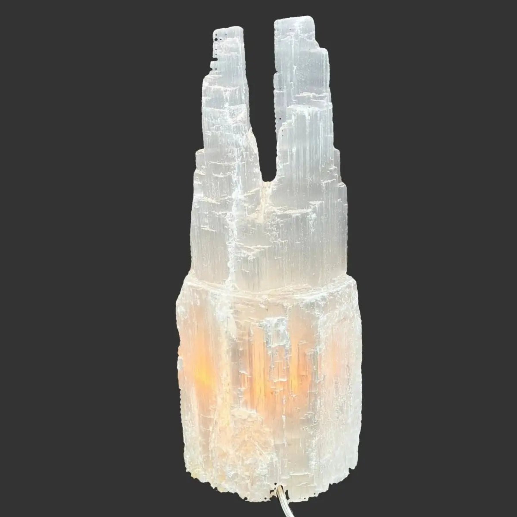 Back side of this Selenite lamp in front of a black background.