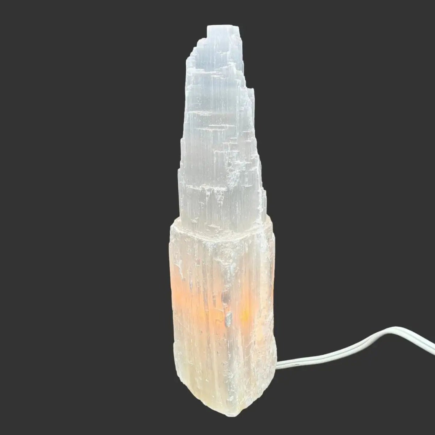 Side View of this Selenite lamp in front of a black background.