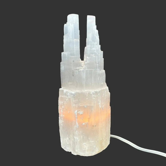 Front side of this Selenite lamp in front of a black background.