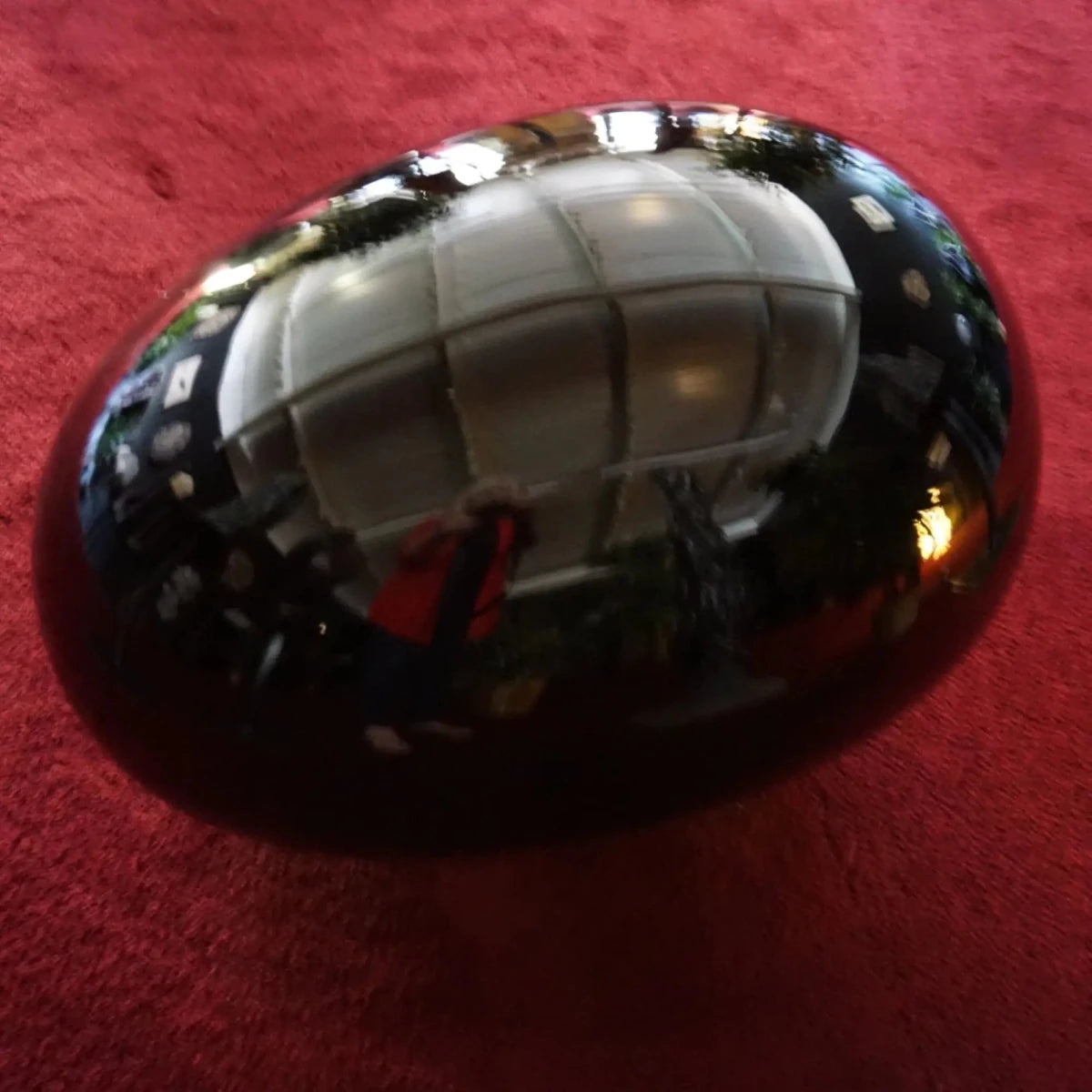 Large Black Obsidian Egg On Burgundy Carpet