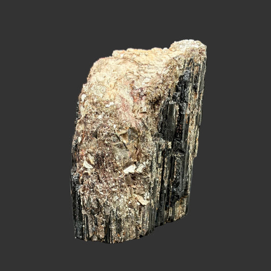This is the front view of this piece of free-standing Tourmaline. It is lack, cream, and gold in color.
