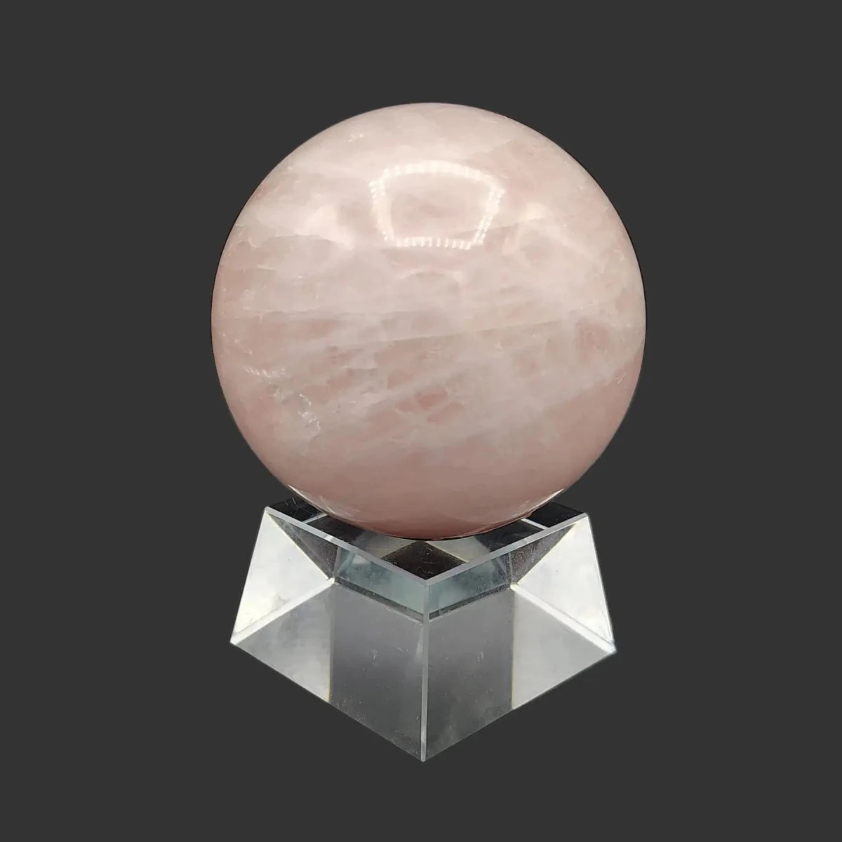 This is the left side oof this polished pink rose Quartz sphere on a clear and chunky square stand.