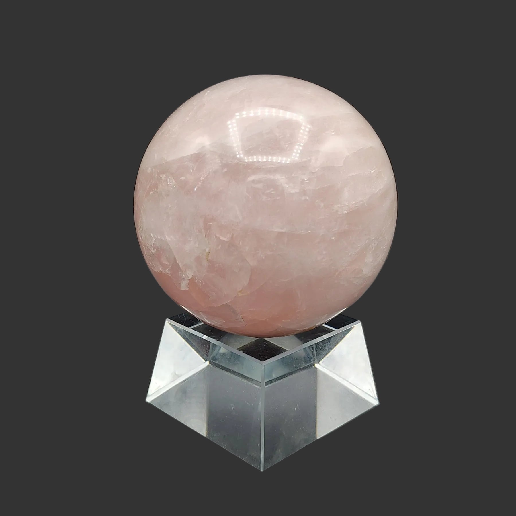 This is the face of this large pink rose Quartz sphere, on a clear chunky and square stand.