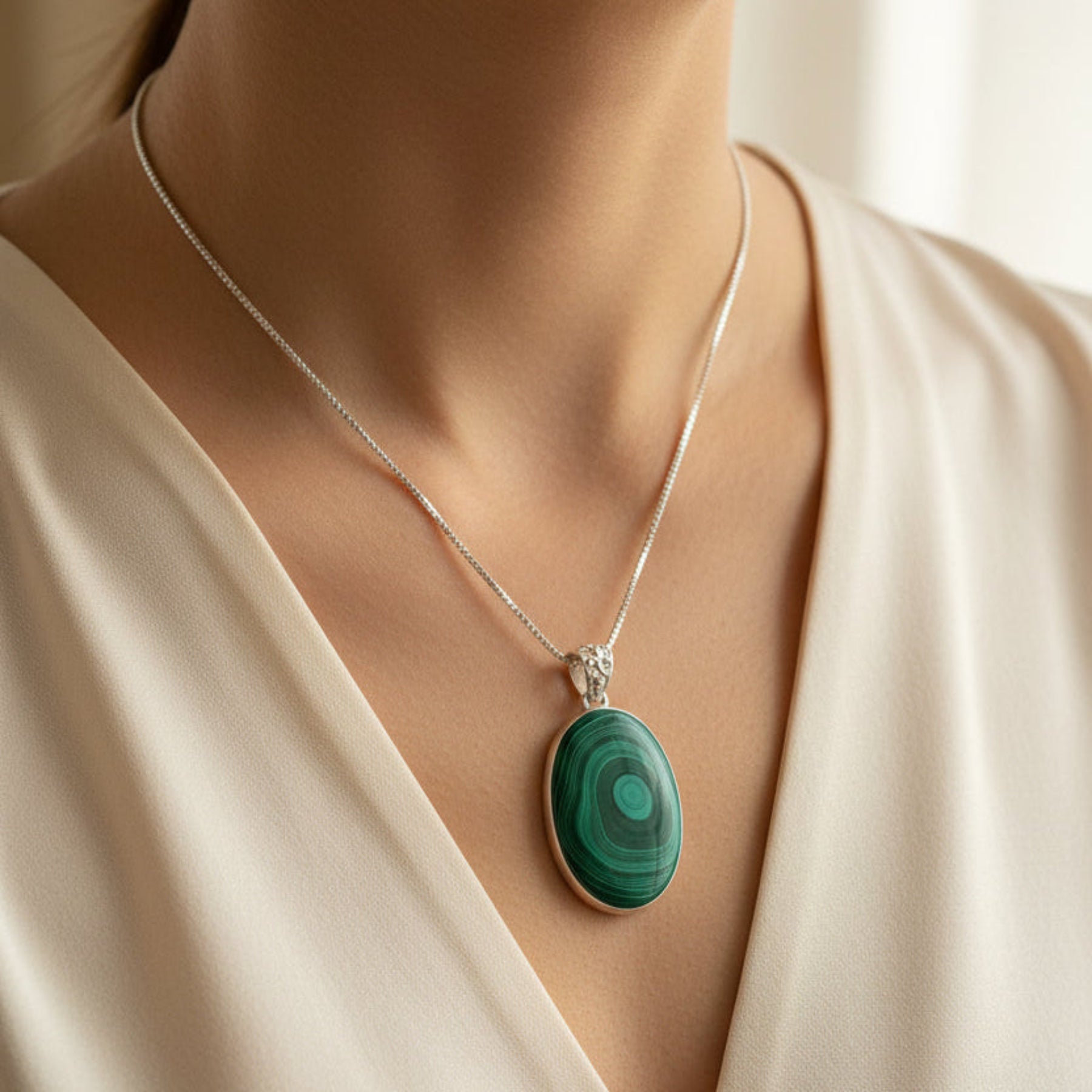 Sterling Silver and green Malachite pendant necklace around a woman's neck.