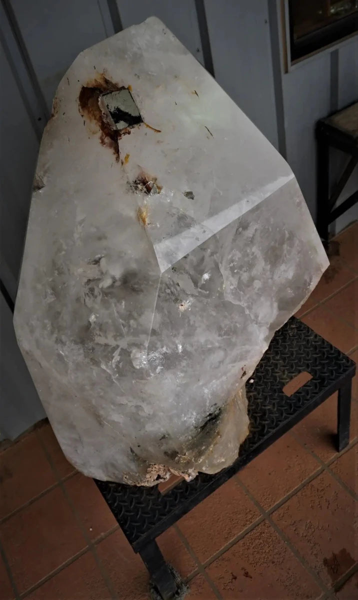 Large Quartz Crystal Point With Pyrite Growth Sitting On A Stand