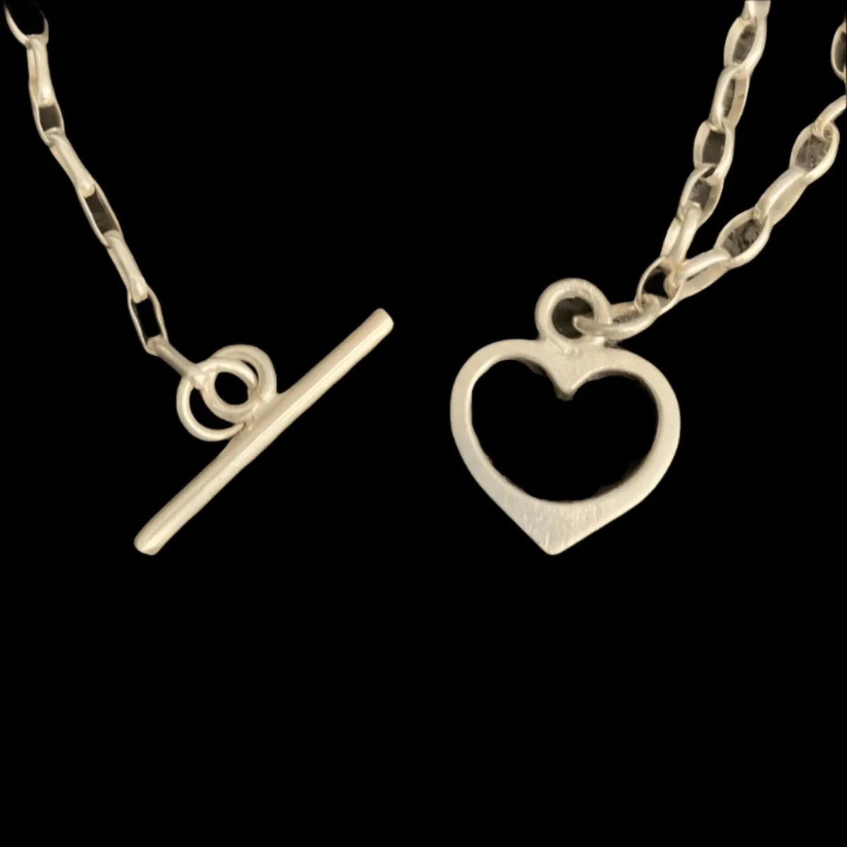 sterling silver link bracelet showing a heart clasp and bar closure