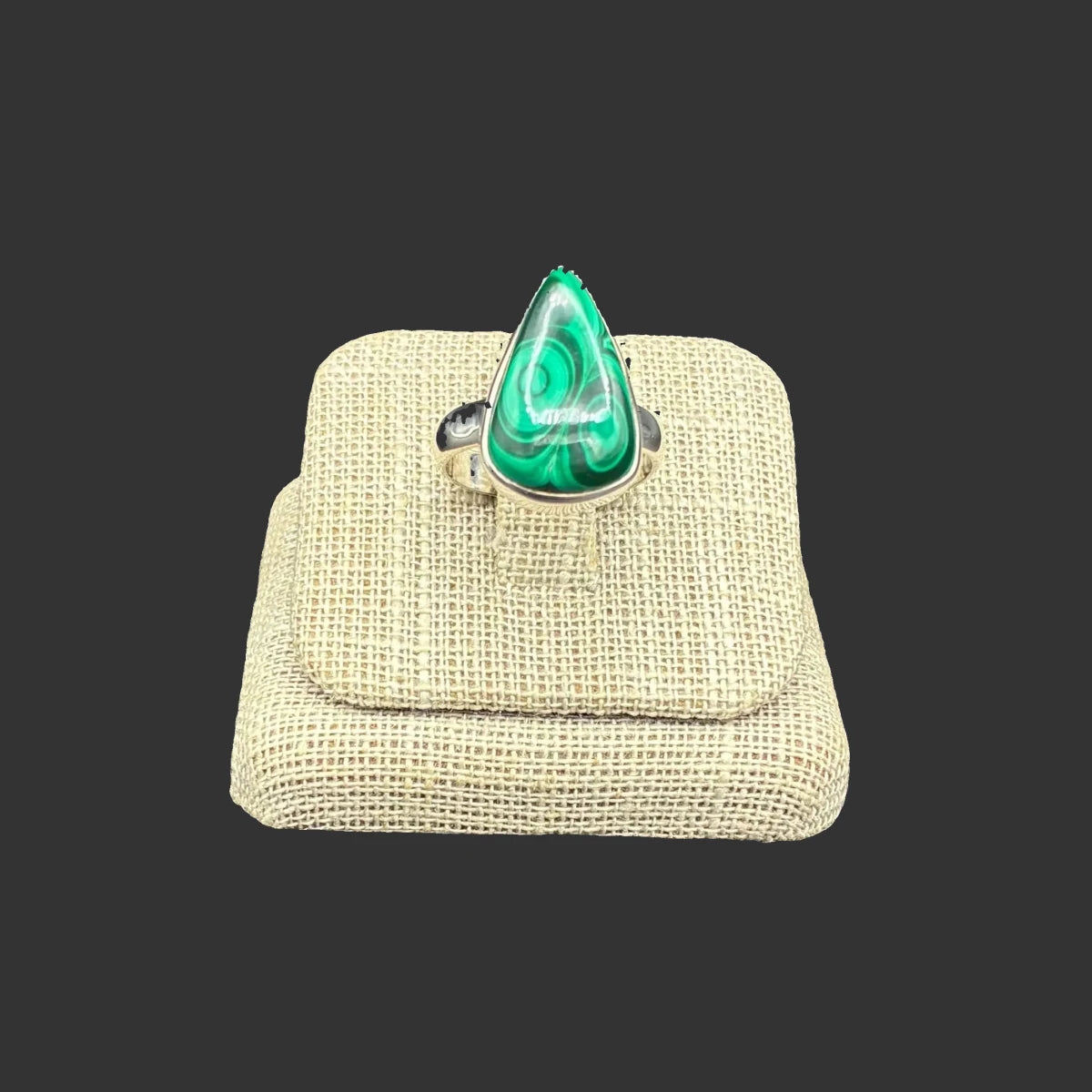 Front view of this Sterling Silver and green malachite ring, in front of a black background.