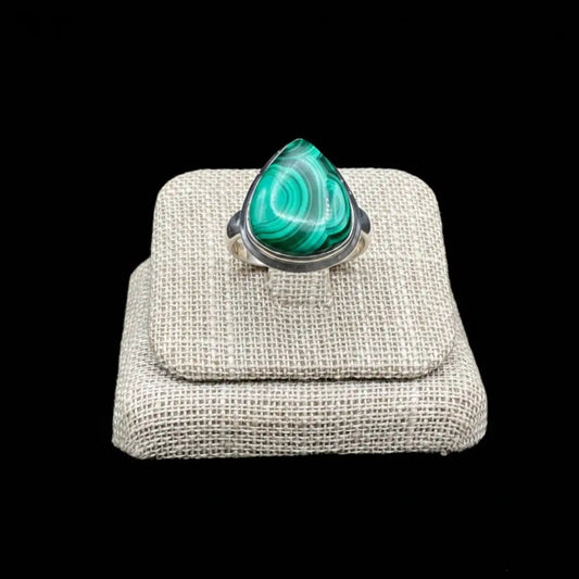 Close up of the front of this Sterling Silver and green Malachite ring, in front of a black background.