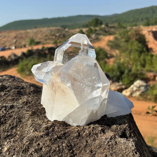 Front view of this quartz crystal cluster, on a rock outdoors.